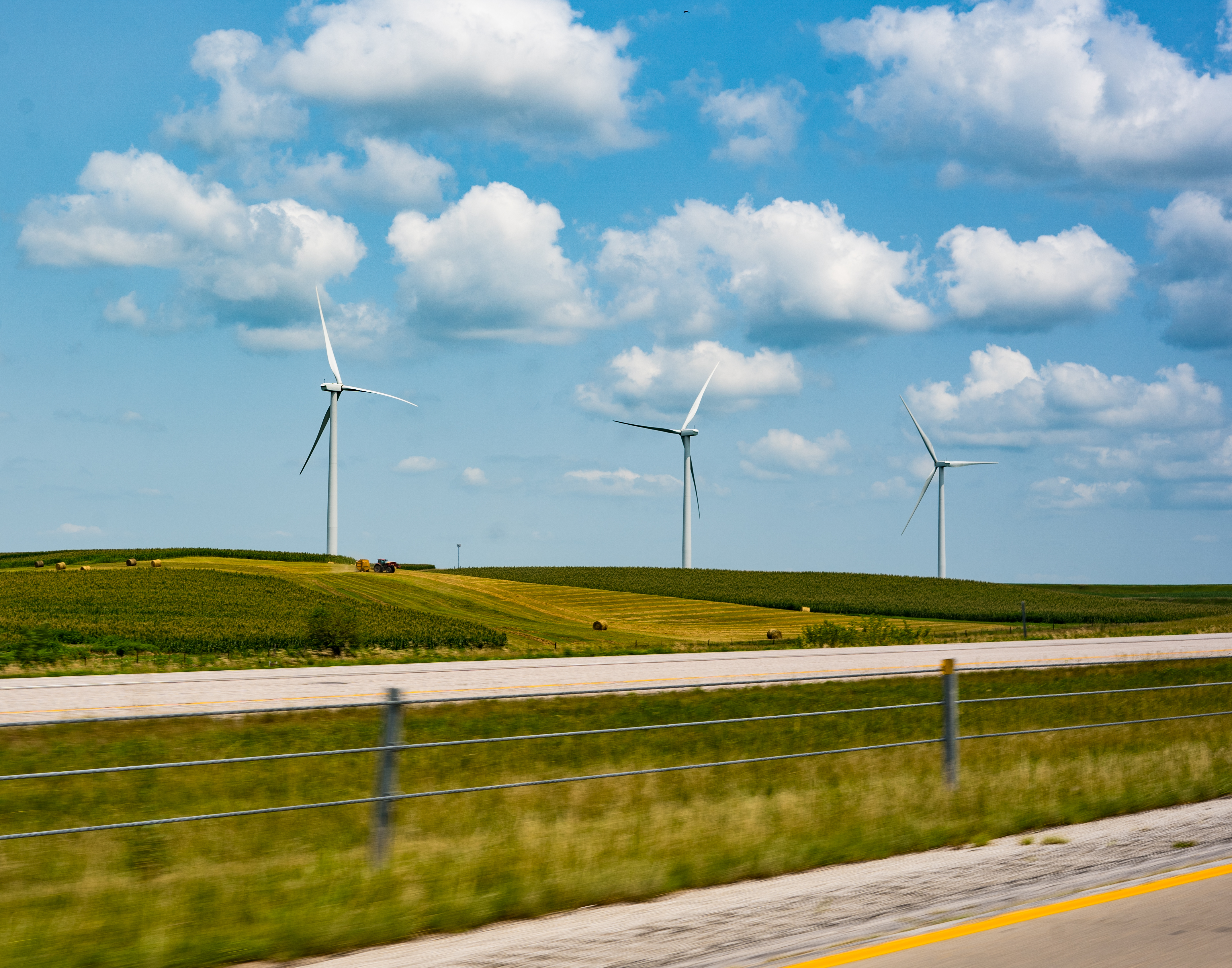 road with farm and windmills in the distance