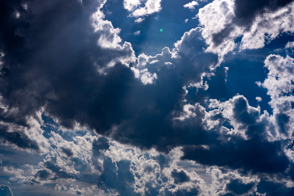 A blue sky with many large clouds