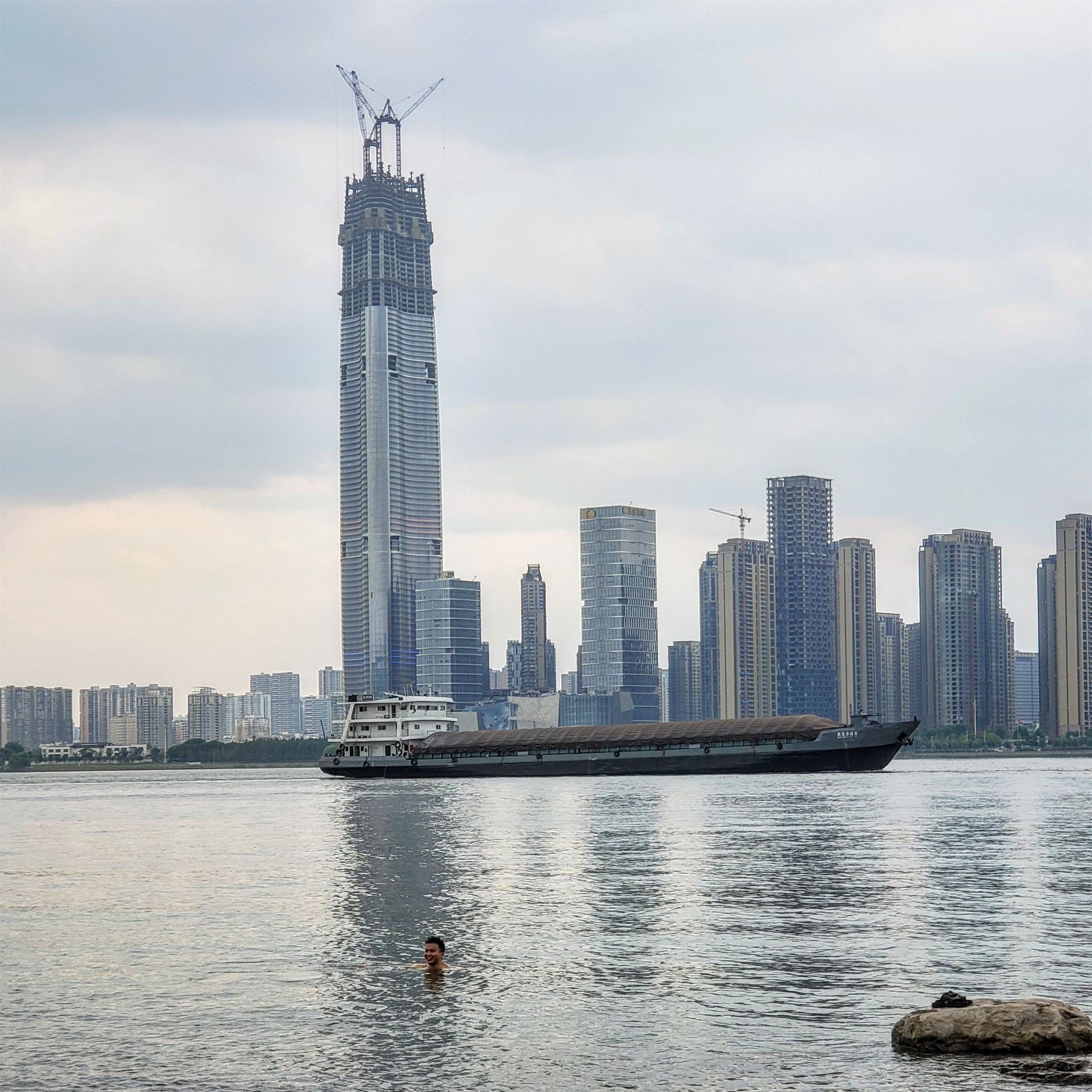 a swimmer in the yangtze river with city in the distance
